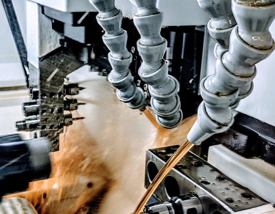 Coolant flowing over a Swiss turning setup mid-cut